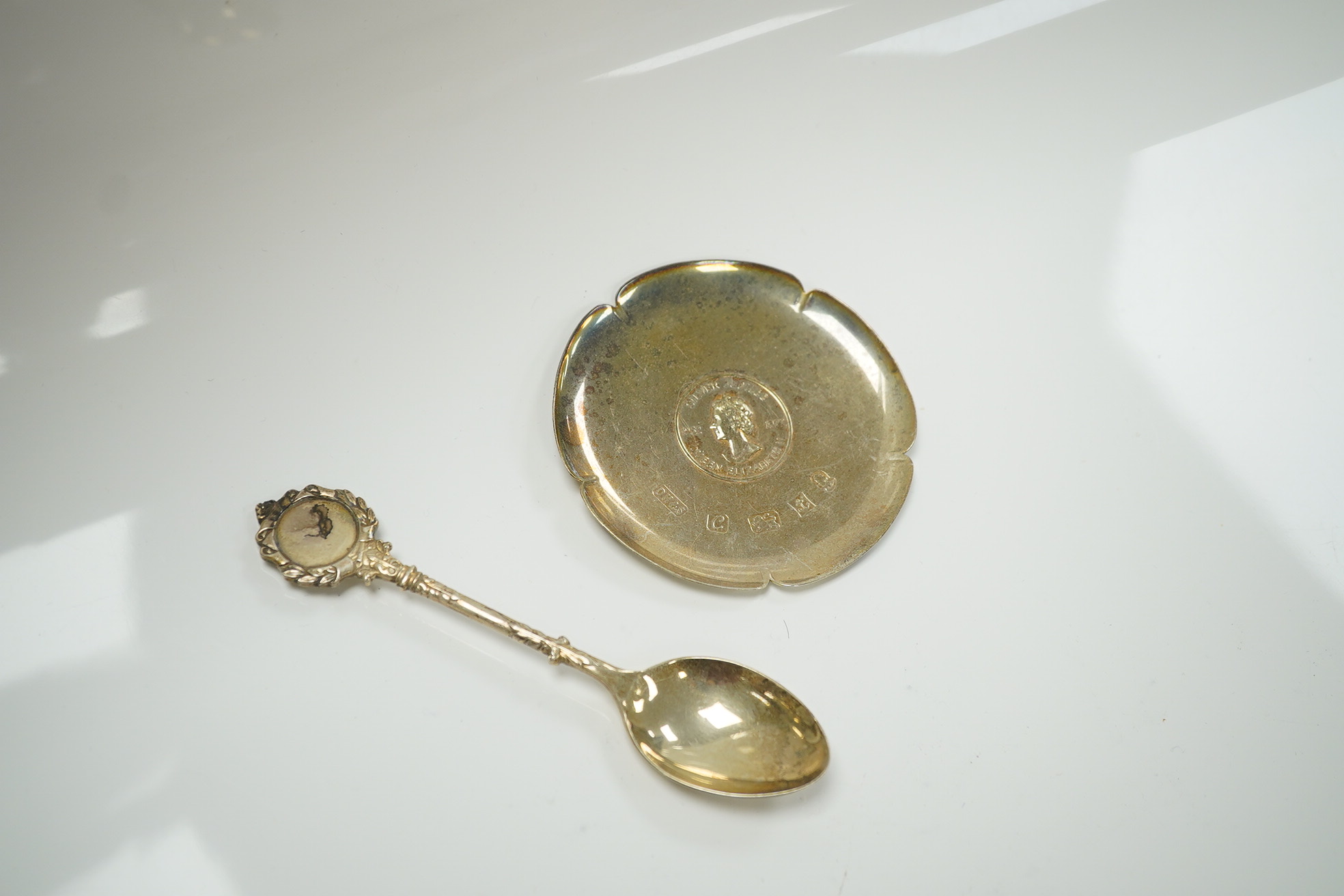 Sundry silver including a silver salver by Garrard & Co, London, 1964, two small dishes, napkin ring, pepperette, a mounted glass butter dish, spoon and a mounted hand mirror and brush, 23.3oz. Condition - poor to fair